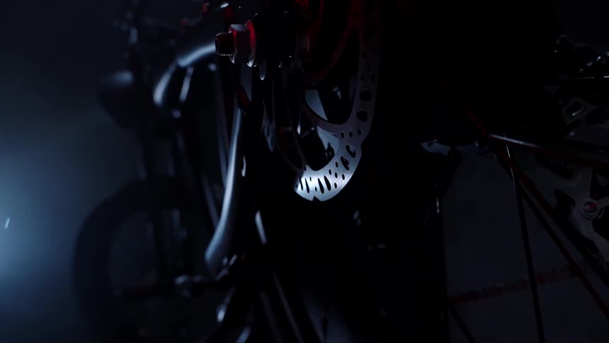 Low light illuminates the surface of the gears of a motorcycle