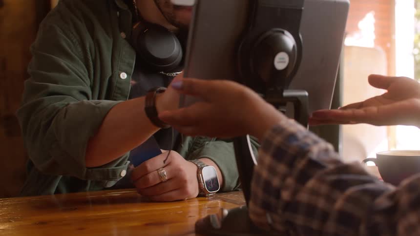 Employee on a coffee shop process a customer payment