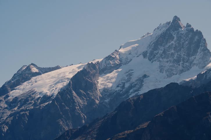 Peak of a mountain covered in snow during the day