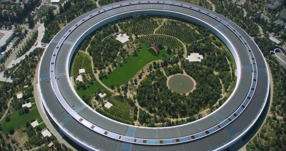 An aerial view of a round building with green vegetation inside