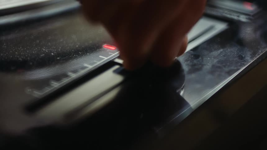 A close up clip of a person increasing the volume of a disk player