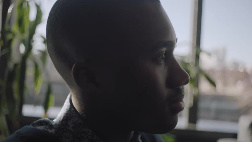 Profile of a young man sitting in an office at morning