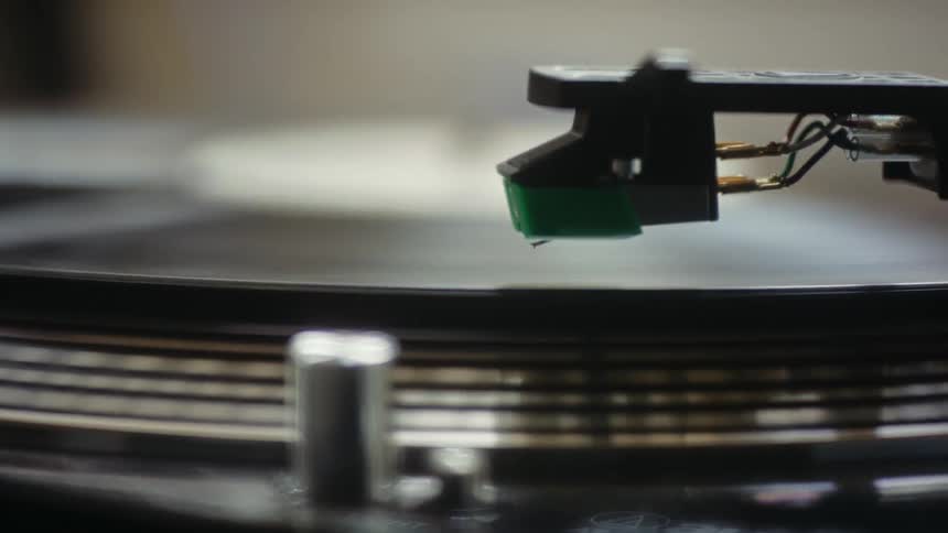 A record player places its arm on the vinyl