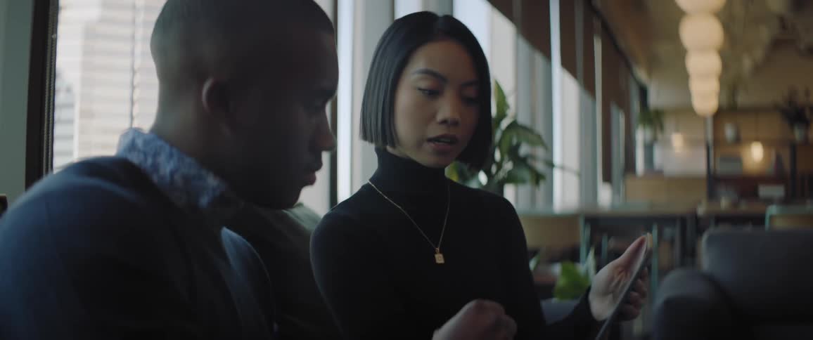 A woman and a man analyzing something on a laptop in an office