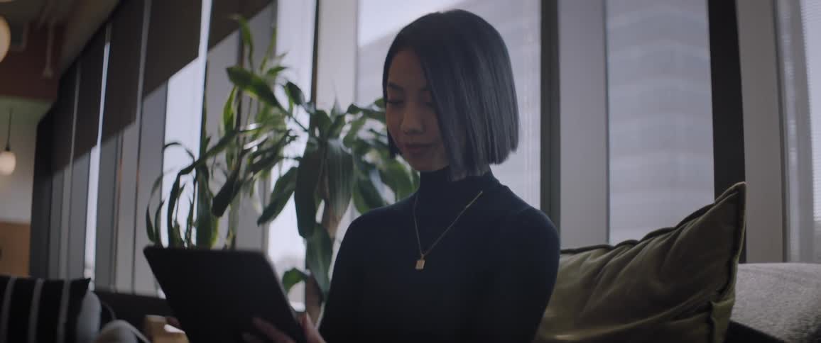A clip of an asian woman operating her tablet in the office