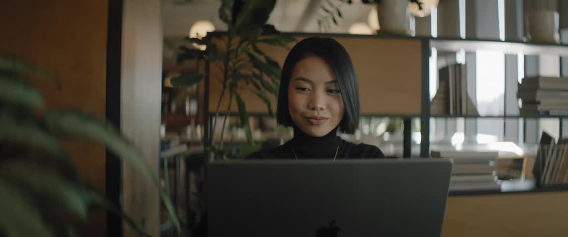 A lady sitting in the office and operating her laptop