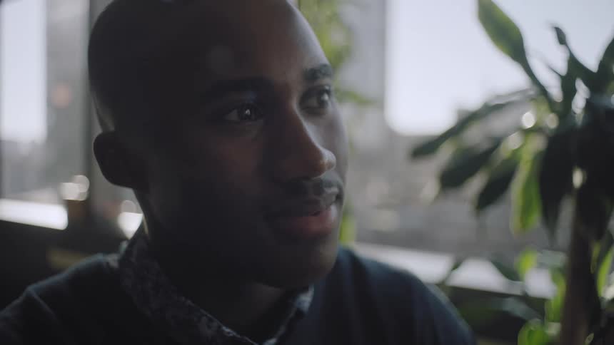 A close up clip of a face of an african man smiling