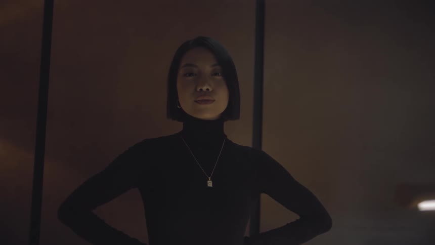 Lady stands indoor with both hands placed on the waist