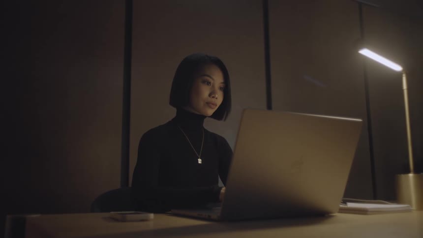 A woman is typing on the laptop
