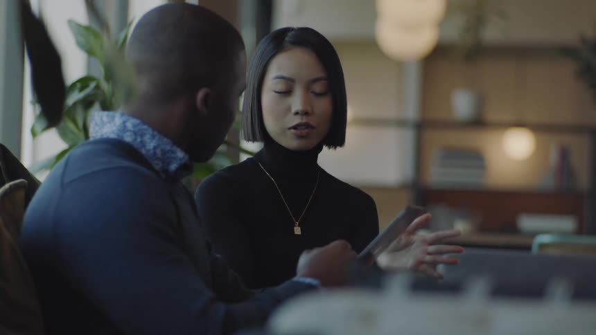 A young woman is talking to a man who is paying attention to the conversation