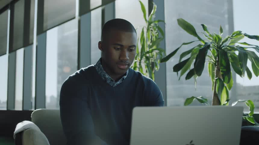 A boy typing on a laptop in the office
