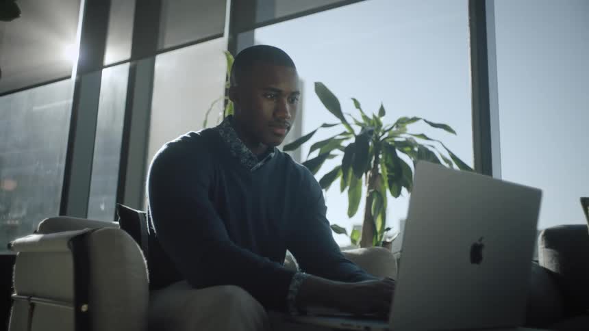A man is looking at his laptop in the office