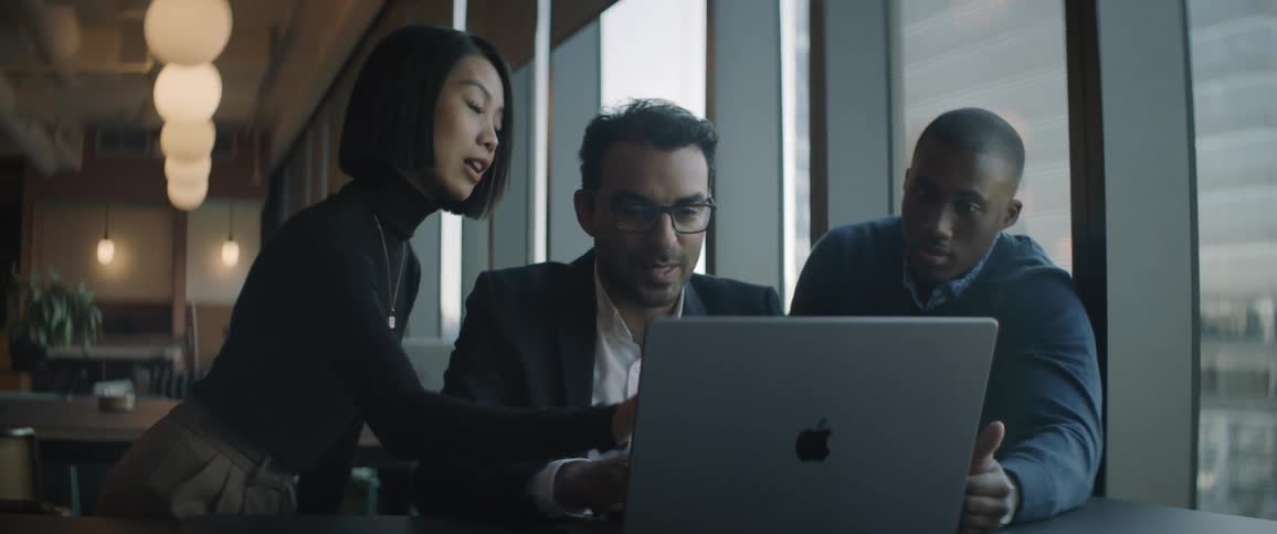 Coworkers look at a laptop together