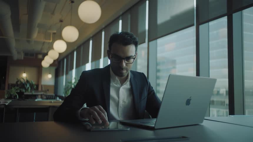 Businessman with a laptop and a tablet working at the office