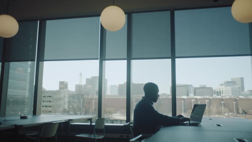 Young man typing on a laptop at the office