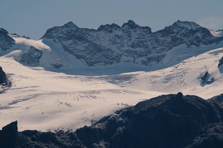 A large mountain of rocks with its surface covered in snow