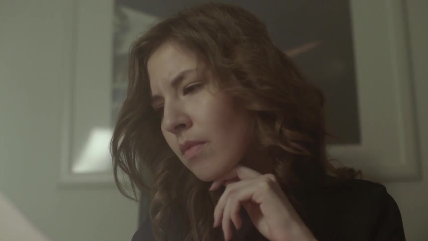 A woman experiences a moment of deep concentration while reviewing a printed research report.