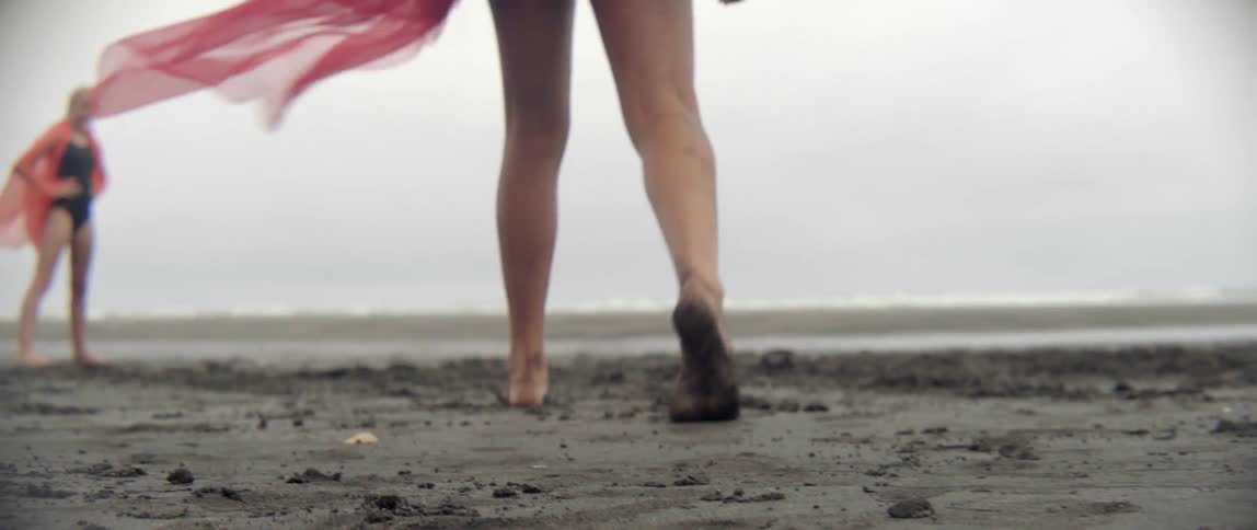A melancholic person explores a misty and overcast beach during a quiet afternoon getaway.