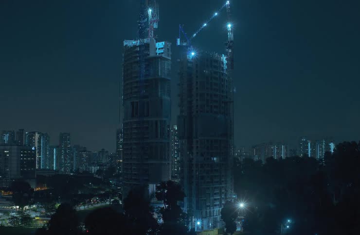 Time lapse of a pair of skyscrapers being built in the city at night