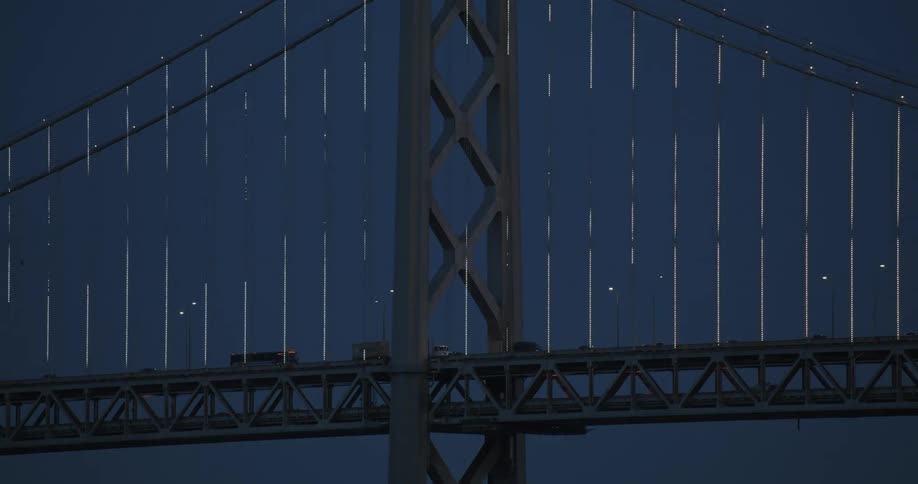 Vehicles crossing a suspension bridge at night