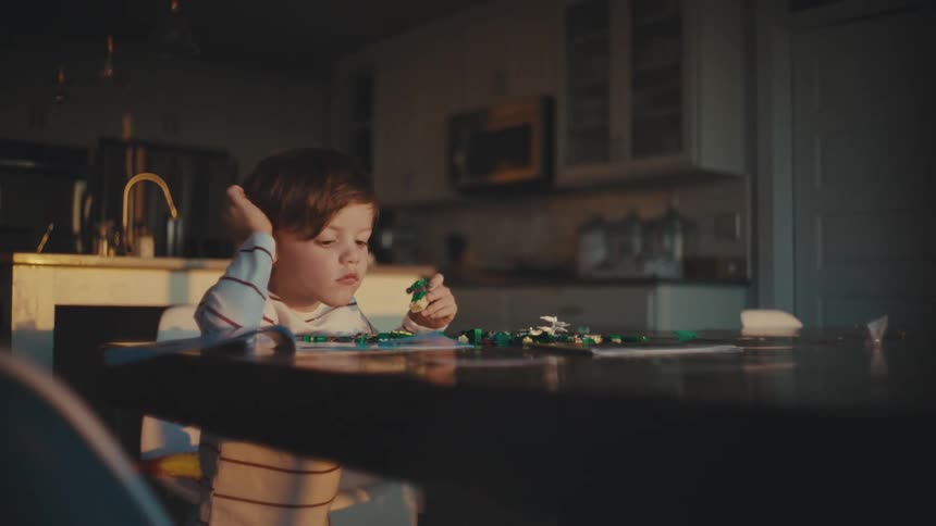 Boy playing alone with toys at home in the morning