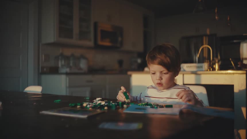 Boy playing alone with toys at home in the morning