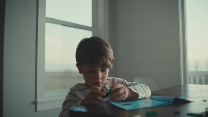 Boy playing alone with toys at home in the morning