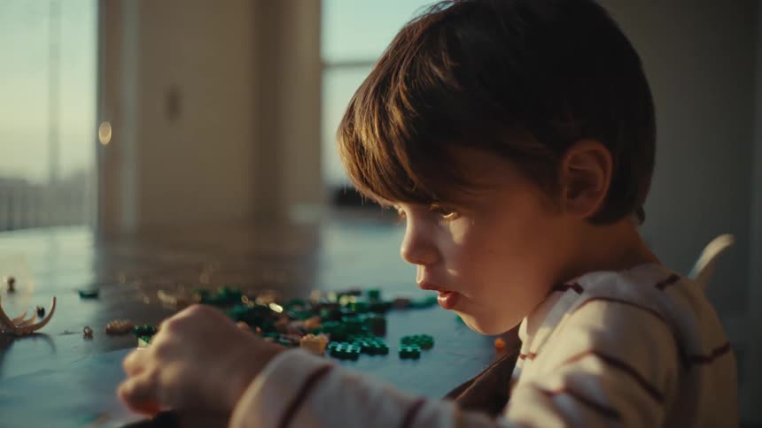 A little boy playing with lego pieces on the table