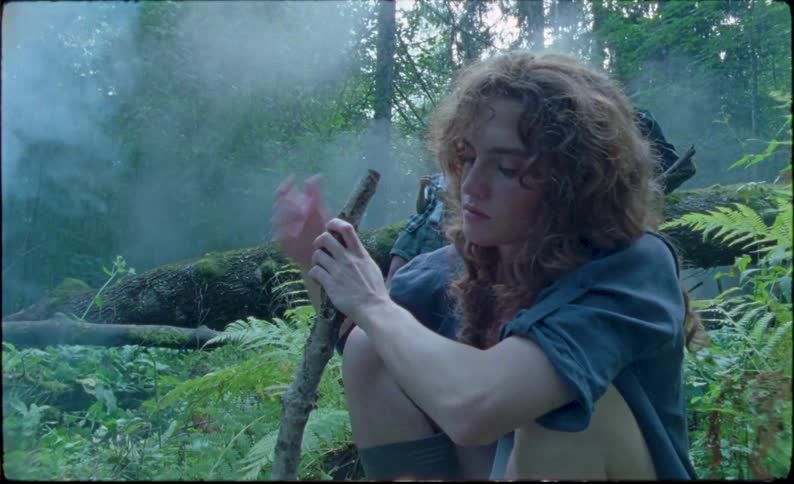 Young people build a fire in a forest during the day