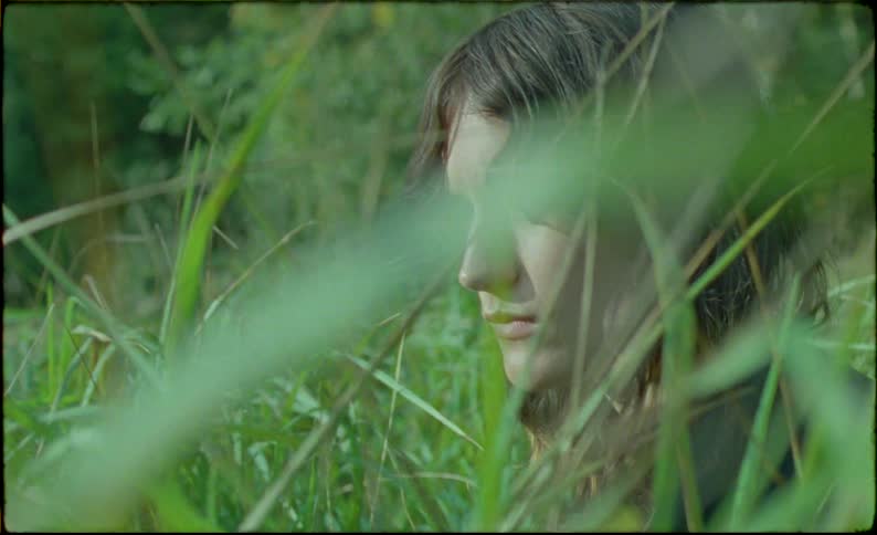 A girl running through the field on a cloudy day
