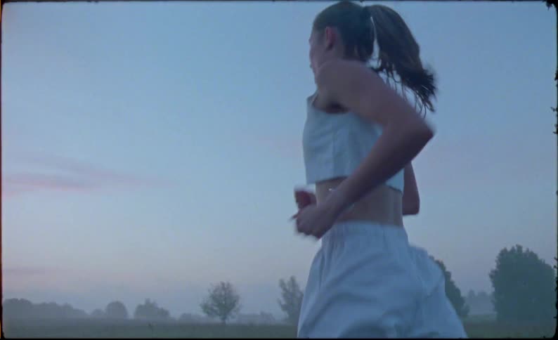 Woman with ponytail runs outdoors at dusk