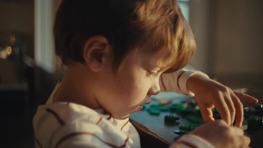Boy playing alone with toys at home in the morning