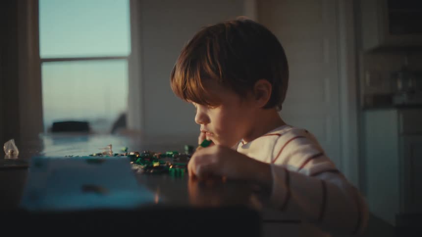 Boy playing alone with toys at home in the morning