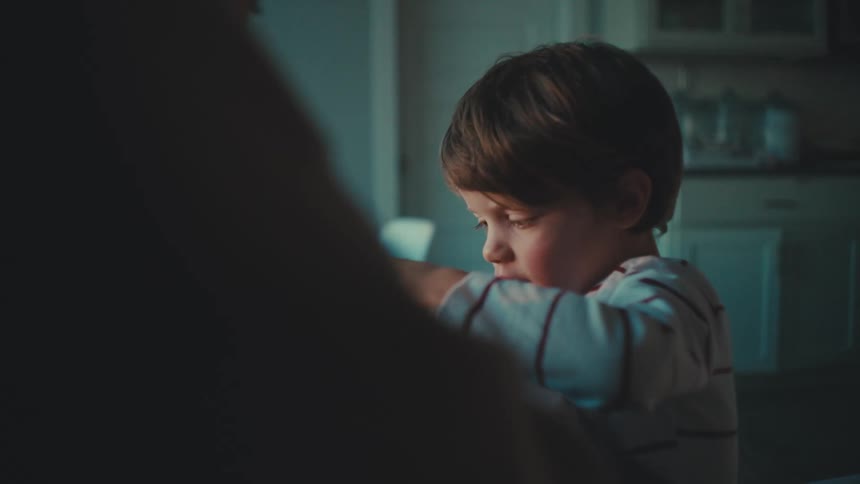 A father and small boy sitting at a table high fiving each other