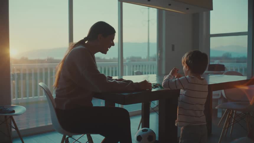 Mother playing with her son in the living room at morning