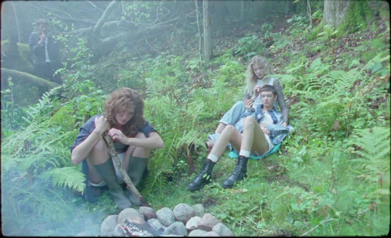 Teenagers sit around the campfire