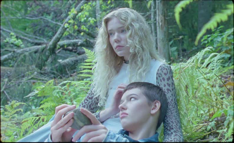 Two girls sit in the forest during the day