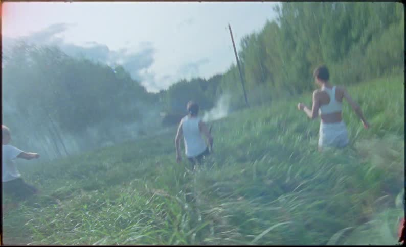A group of teenagers run towards the smoke