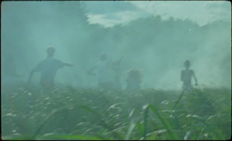 Group of friends running towards smoke in the countryside