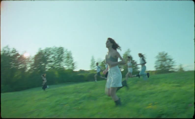A group of friends running in a meadow during the day