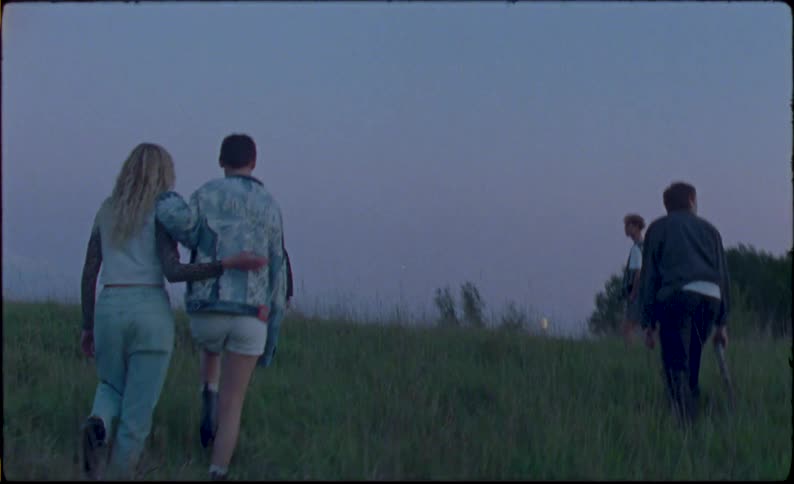 Group of friends walking on a hill at sunset