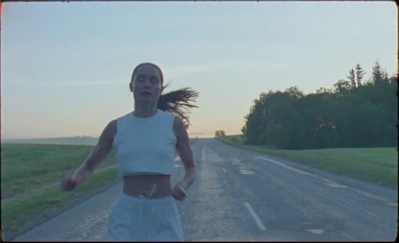 A woman is running on a quiet rural road