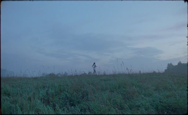 Young fit woman jogs over a treadmill in the countryside caught on vintage film