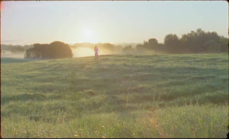 A woman runs through the tall grass