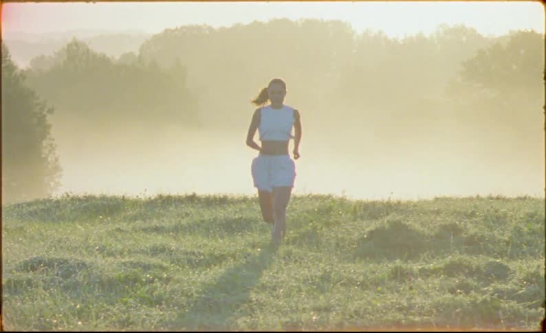 A woman is running through the grass