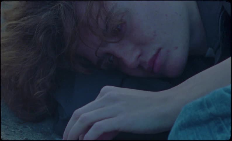 Close up of the face of a young woman laying in the ground