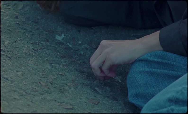 A crying woman lying on the ground during sunset