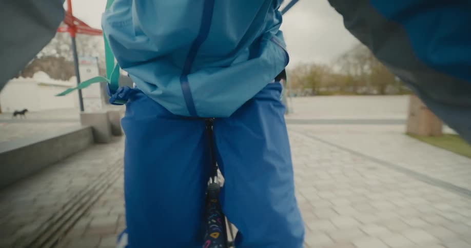 A person bikes along a brick path before jumping off of their bicycle