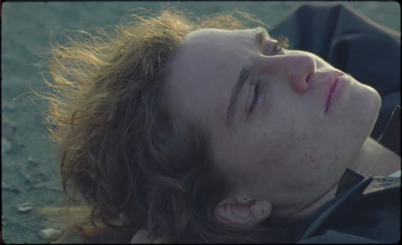Close up of the face of an attractive young person laying on the ground
