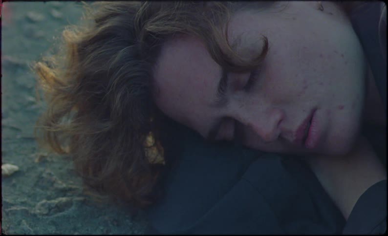Close up of the face of a young beautiful person laying in the ground